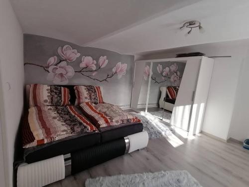 1 dormitorio con 1 cama con un mural de flores en la pared en Ubytování Dobešov en Černovice