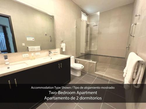 ein Badezimmer mit einem Waschbecken, einem WC und einem Spiegel in der Unterkunft Cárdenas Suites in Puerto Vallarta