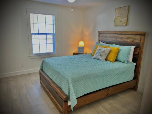 a bedroom with a bed with blue and yellow pillows at Coastal Escape: Sleek King Suite on Half Acre in Gulfport