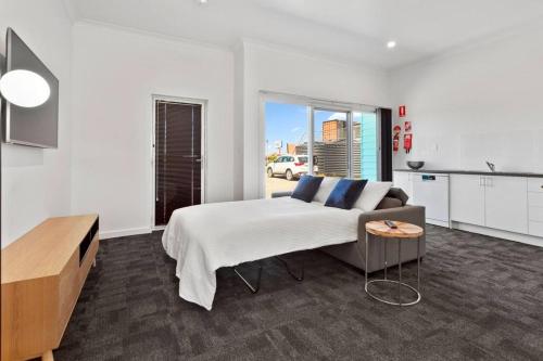 a large white bedroom with a bed and a table at Port Lincoln Shark Apartment 4 in Port Lincoln