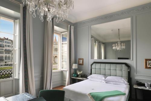 1 dormitorio con cama y lámpara de araña en The Place Firenze, en Florencia