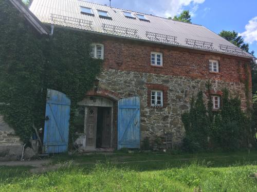 une ancienne maison en briques avec portes et fenêtres bleues dans l'établissement Flat 56, à Stara Kamienica