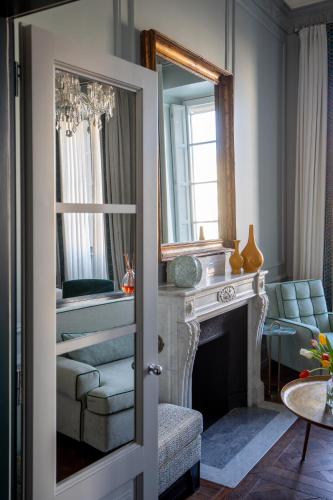 a living room with a fireplace and a mirror at The Place Firenze in Florence