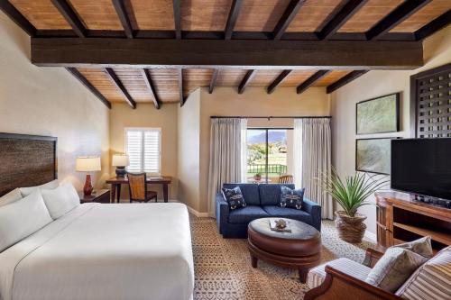 a bedroom with a bed and a couch and a tv at Omni Tucson National Resort in Tucson