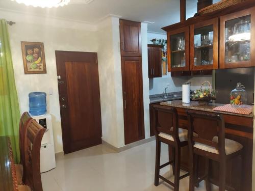 a kitchen with a island in the middle of a room at Jardines de tu sueño. in Santiago de los Caballeros