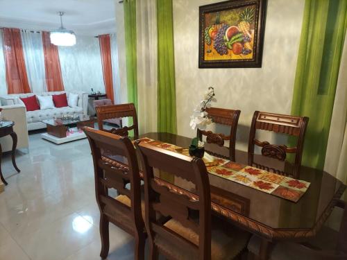 a dining room with a wooden table and chairs at Jardines de tu sueño. in Santiago de los Caballeros