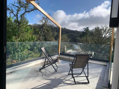 two chairs sitting on the balcony of a house at Villa Cerrado das Fontainhas SPA in Sintra