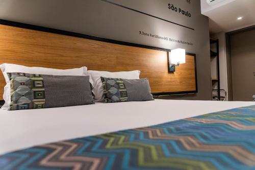 a hotel room with a bed with pillows at Monreale Lifestyle Higienópolis São Paulo in São Paulo