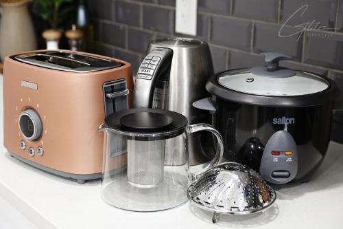 a kitchen counter with a toaster and a tea kettle at Chic Modern Home,King Bed,Fireplace,Disney in Edmonton
