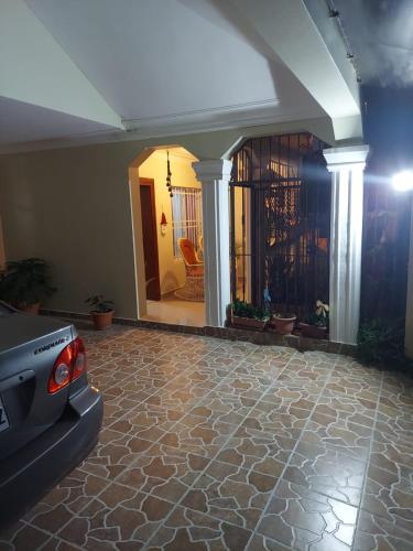 a living room with a car parked on a stone floor at Jardines de tu sueño. in Santiago de los Caballeros