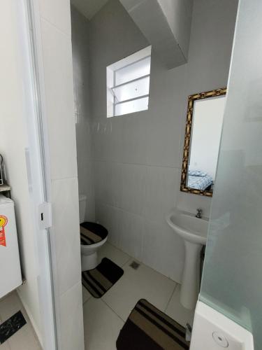 a bathroom with a toilet and a sink at Aconchego Sagrada face 2 in Aparecida