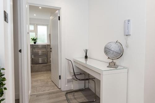 een wit bureau in een witte kamer met een spiegel bij Lorne Park Suite in Bournemouth