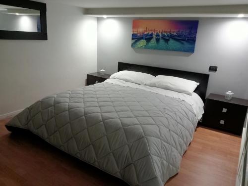 1 dormitorio con 1 cama grande y una pintura en la pared en Maison Damas, en Barletta