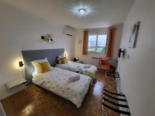 sypialnia z 2 łóżkami i oknem w obiekcie Maison VENITIA w mieście Aussonne