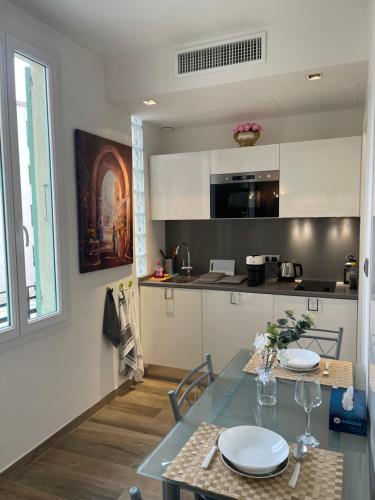 une cuisine avec une table avec des chaises et une salle à manger dans l'établissement NICE City-Center 80m to the SEA / BEACH, à Nice