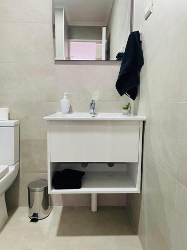 y baño con lavabo blanco y espejo. en Inmobiliaria Avellano, en Los Ángeles