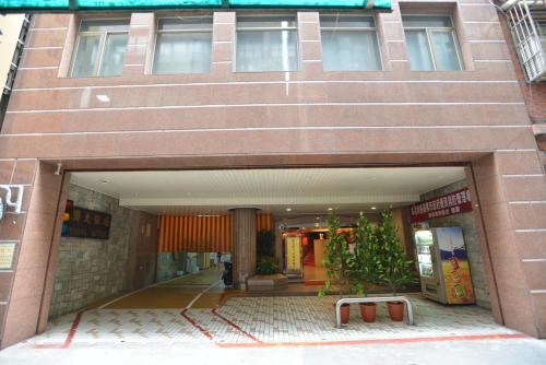 a large brick building with a walkway in front of it at Hua Guo Hotel in Keelung