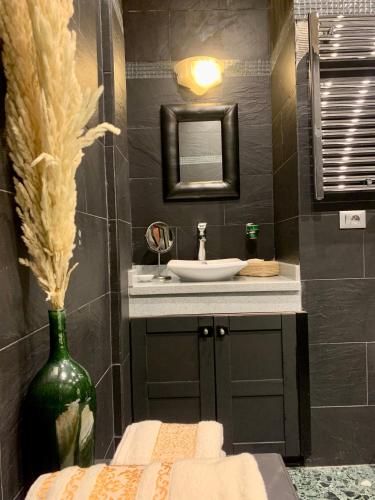 a bathroom with a sink and a vase with a mirror at Riad Ksar Saad & Spa in Marrakech
