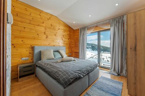 a bedroom with a bed and a large window at Vila Cigota Zlatibor in Zlatibor