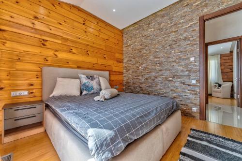 a bedroom with a bed and a brick wall at Vila Cigota Zlatibor in Zlatibor