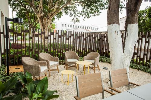 a group of chairs and tables next to a fence at Travel Inn Hotels Wise Indaiatuba in Indaiatuba