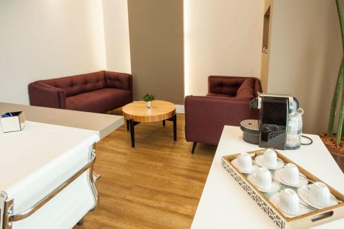 a living room with couches and a table with cups at Travel Inn Hotels Wise Indaiatuba in Indaiatuba