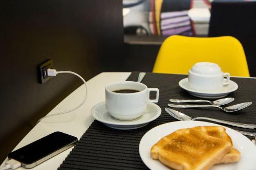 a table with a cup of coffee and a piece of bread at Travel Inn Hotels Wise Indaiatuba in Indaiatuba
