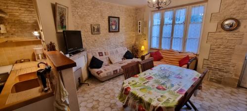 a living room with a table and a couch at Maison de vacances bord de mer Normandie plage du débarquement proche Caen in Bernières-sur-Mer