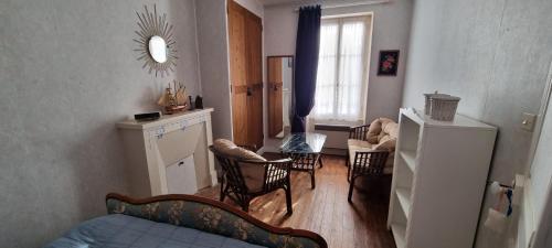 - un salon avec des chaises, une table et une fenêtre dans l'établissement Maison de vacances bord de mer Normandie plage du débarquement proche Caen, à Bernières-sur-Mer