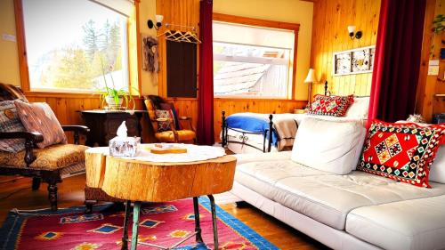 a living room with a couch and a table at La vieille ferme, Écogîte in Saint-Fulgence