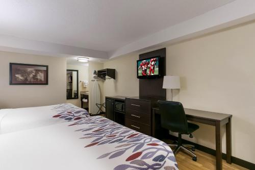 a hotel room with a bed and a desk and a television at Red Roof Inn Hershey in Hershey