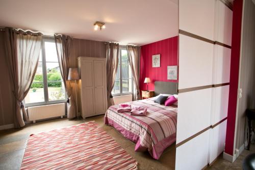 1 dormitorio con cama y pared roja en Gîte Vassy-Etaule Spa Privatif, 