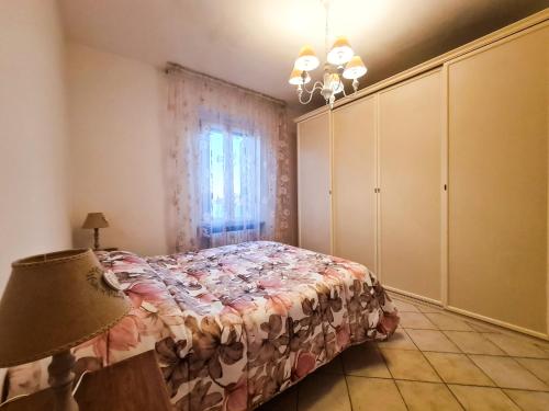 ein Schlafzimmer mit einem Bett, einer Lampe und einem Fenster in der Unterkunft Piccolo Rifugio in Sandigliano