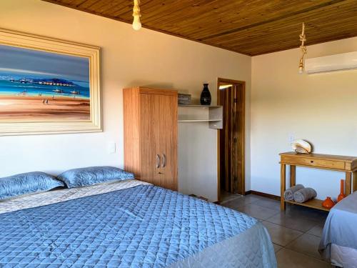 sypialnia z łóżkiem i zdjęciem plaży w obiekcie Via Del Mare Flats w mieście Maraú