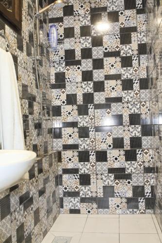 a bathroom with a black and white tiled wall at VILA VASILIJE in Novi Kneževac