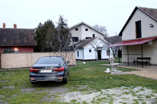 a car parked in a yard in front of a house at VILA VASILIJE in Novi Kneževac