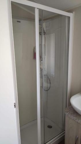 a glass shower in a bathroom with a sink at 6 Berth on John Fowlers (Sandy Glade) Brean in Berrow