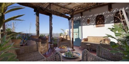 a patio with chairs and a couch and a table at Dar KamalChaoui in Bhalil