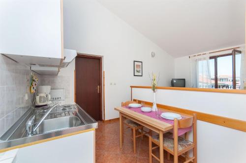 eine Küche mit einem Waschbecken und einem Tisch mit Stühlen in der Unterkunft Apartments Luciana in Rovinj