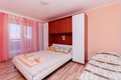 a bedroom with a large bed and a window at Apartments Rajka in Lopar
