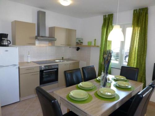 a kitchen with a wooden table with chairs and a dining room at Apartment Ivan in Šilo
