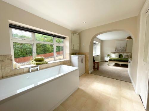 a large bathroom with a large tub and a bedroom at Big House in countryside near Cardiff in Rudry