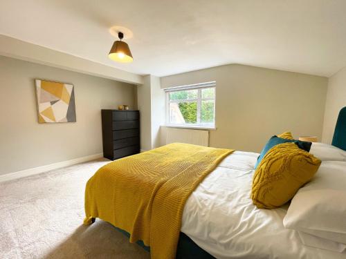 a bedroom with a bed with a yellow blanket on it at Big House in countryside near Cardiff in Rudry