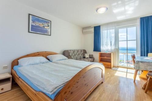 Schlafzimmer mit einem Bett, einem Tisch und einem Fenster in der Unterkunft Apartments Bozana in Dramalj