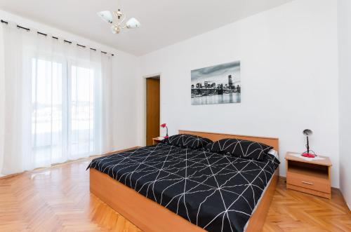 a bedroom with a bed with a black comforter at Apartment Marica Sanja in Palit
