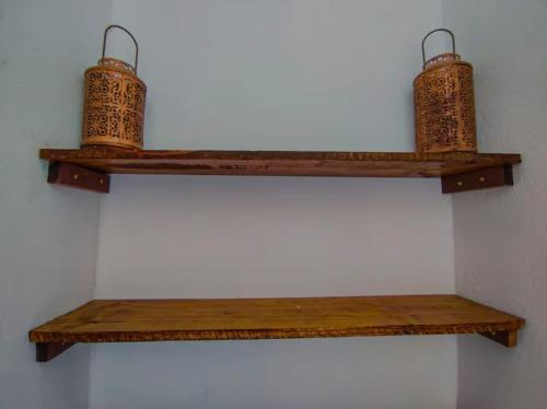 two wooden shelves with baskets on top of a wall at Freddyssimo Preá in Prea