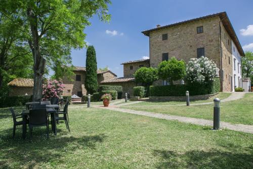 a garden with a table and chairs in front of a building at Borgo La Casaccia in Montaione