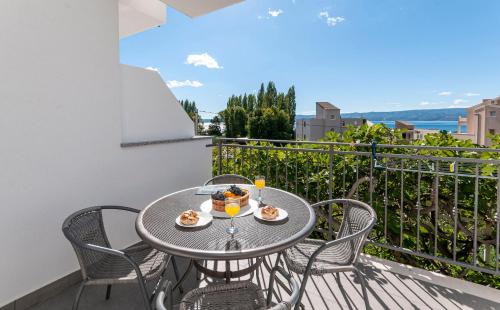 einen Tisch und Stühle auf dem Balkon eines Apartments in der Unterkunft Apartments and Rooms Nikola in Omiš