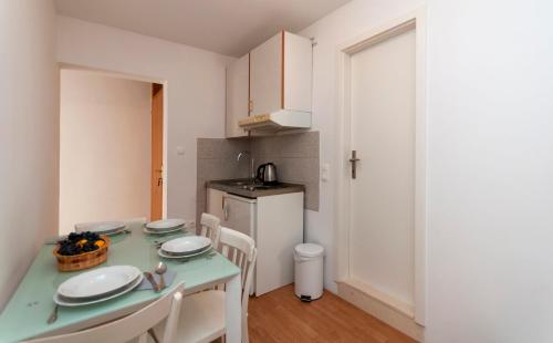 a kitchen with a table and chairs in a room at Apartments and Rooms Nikola in Omiš