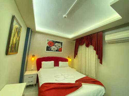 Schlafzimmer mit einem großen Bett mit rotem Kopfteil in der Unterkunft ŞİRİNYER APART OTEL in Izmir